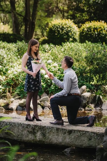 Foto profesional de hombre haciendo una propuesta de matrimonio a su novia en un bosque rodeado por un estanque en Quito