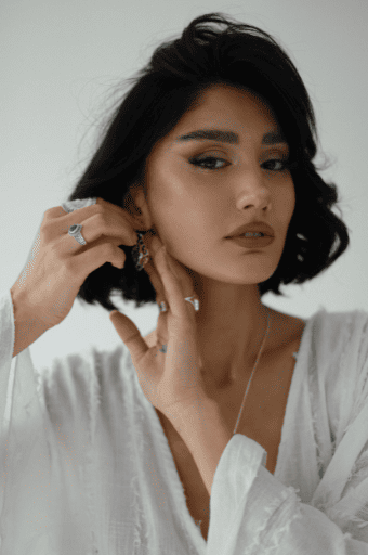 Mujer usando aretes, anillos y collares elegantes con outfit boho