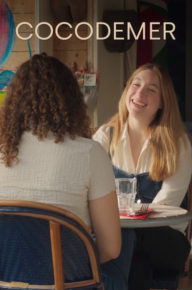 Two women laughing while dining at Cocodemer restaurant with outdoor cafe seating.