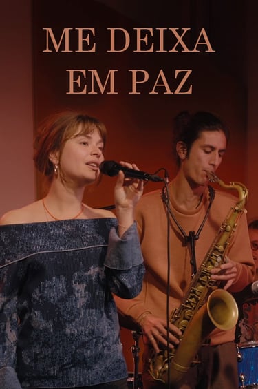 A female jazz singer with a microphone and a male saxophone player performing live on stage.