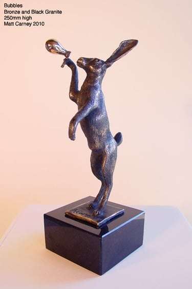 a statue of a rabbit blowing a balloon