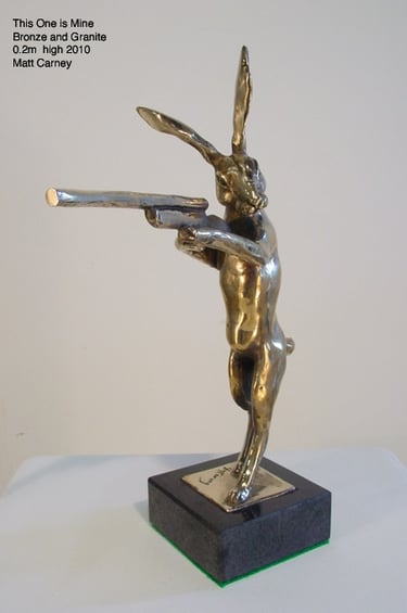 a bronze sculpture of a rabbit with a gun