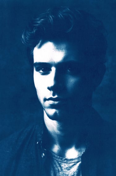 Close-up portrait of a young man with a strong jawline and high cheekbones, featuring dramatic light