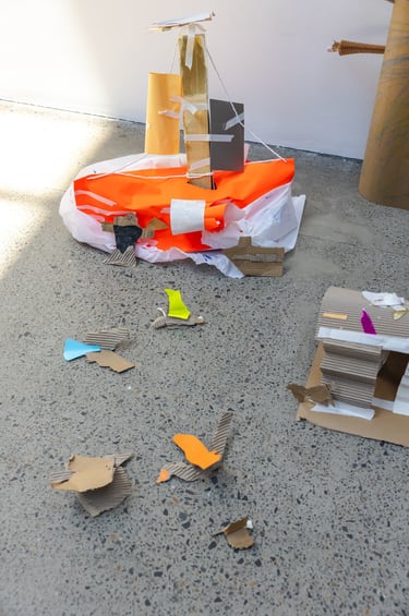 A bright orange and white cardboard structure on the floor.