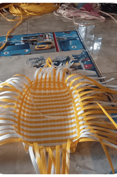 Base structure of a handmade woven bag using natural colored recycled plastic strips at Craftvitas Indonesia.