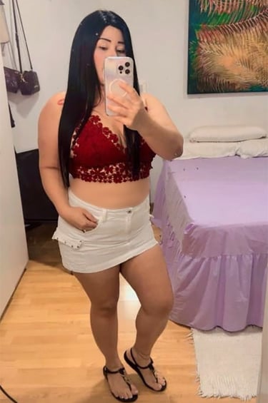 Viky con falda blanca y top rojo, look casual sexy frente al espejo