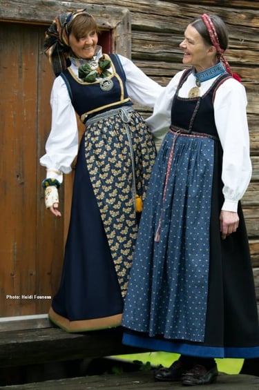 Two women wear bunad with colorful aprons