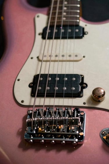 Macro photography of an electric guitar bridge and strings, with a blurred background showing the warm lights of a city at night, reflecting a South American / Venezuelan urban vibe. The colors are rich rose and black, emphasizing the fusion of rock and contemporary pop styles.