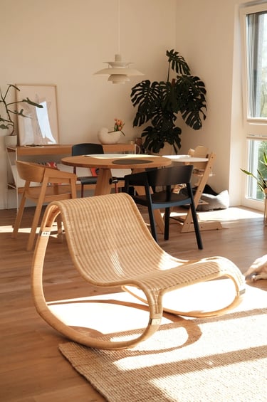 Cozy balcony reading corner with comfortable outdoor chair, small side table, warm lighting, plants,