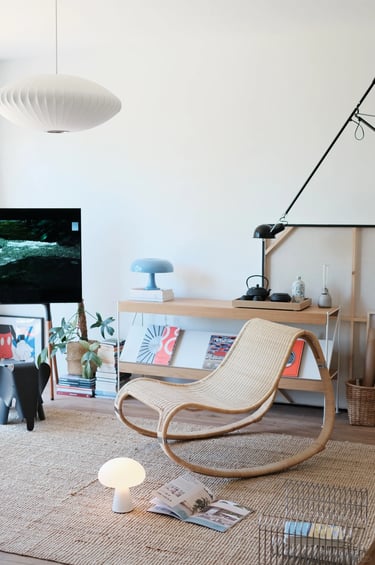 Cozy balcony reading corner with comfortable outdoor chair, small side table, warm lighting, plants,
