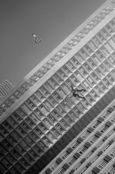 Des hommes planent entre les immeubles d'une cité