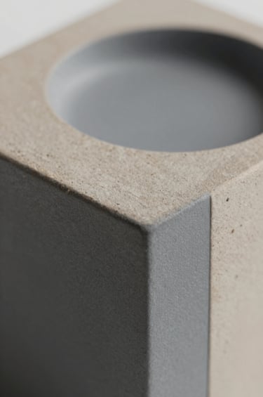 A close-up detail of a collectible edition piece, showcasing sustainable artistic practice. The object features a mix of natural textures and refined finishes in #5B7B71 and #293B37. The composition is artistic and intellectual, shot with a shallow depth of field.