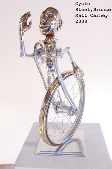 a silver and bronze sculpture of a man as a bicycle
