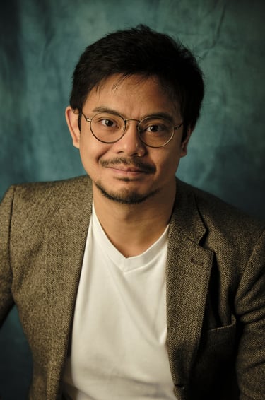 a man in a suit and glasses poses for a portrait