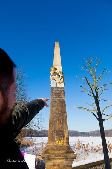 Reiseleiter, der auf einen Obelisken im Schloss Moritzburg zeigt.
