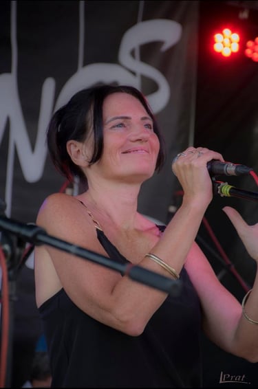 Claire Long singing at a festival summer 2025