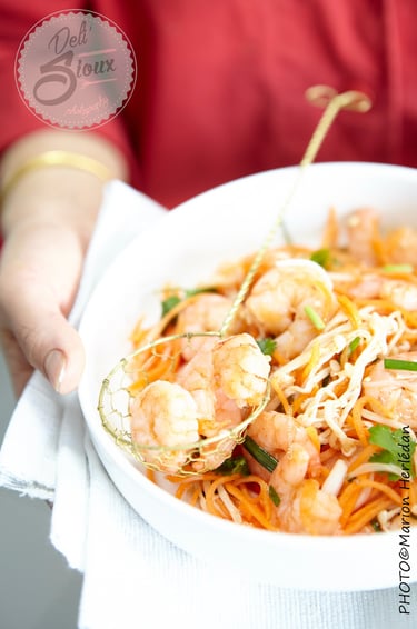 pad thaï de crevette dans un bol blanc tenu pas deux mains en gros plan