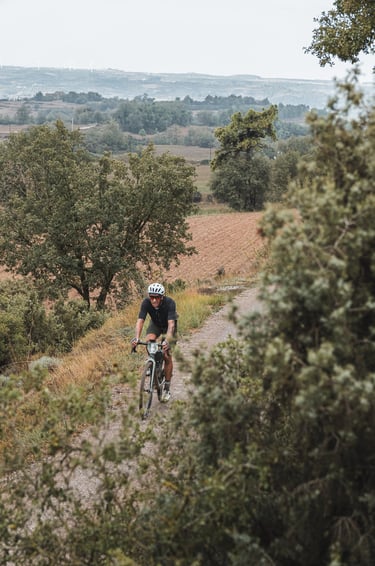 a man riding a bike down a dirt road