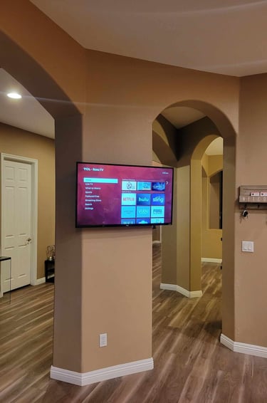 a flat screen tv mounted on an archway in a house