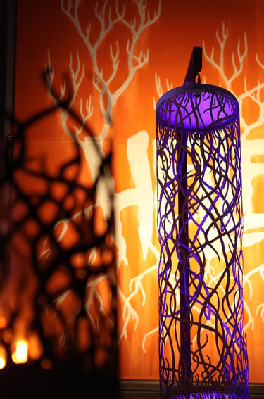 a group of three tall purple lanterns with birds on them