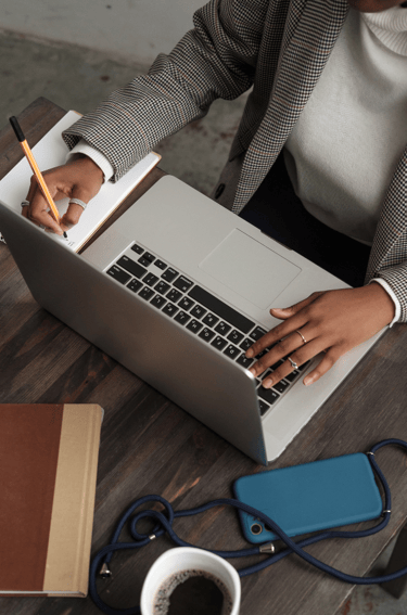 Personne écrivant dans un carnet tout en travaillant sur un ordinateur portable, Réflexion