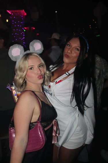 Two women in mouse ears and Flo from Progressive costumes posing for a Halloween party photo.