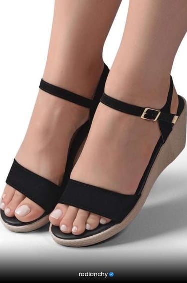 a woman's feet wearing a pair of black sandals