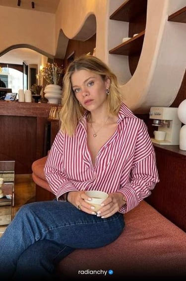 a woman sitting on a couch with a cup of coffee