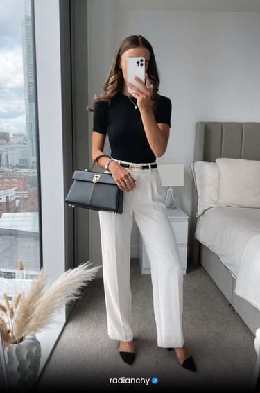 a woman in a black top and white pants