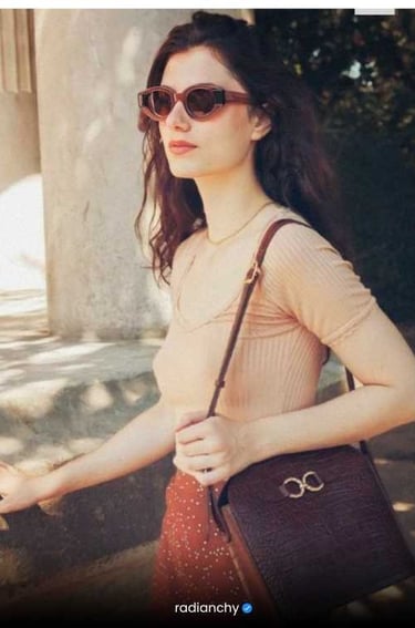 a woman in a short sleeved top and sunglasses