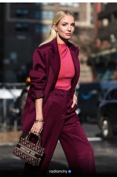 a woman in a pink sweater and pantsuituit with a handbag
