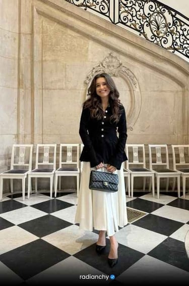a woman in a black jacket and white skirt