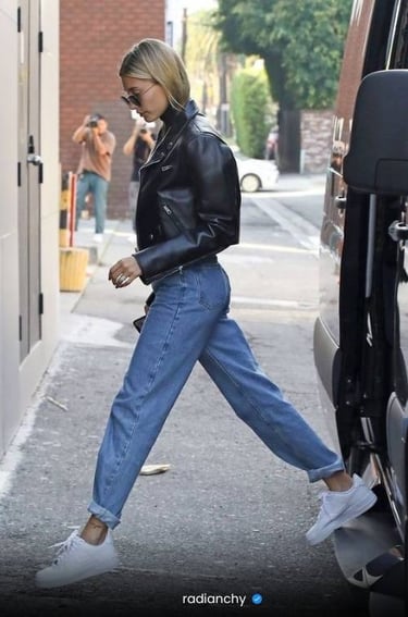 a woman in a black leather jacket and jeans