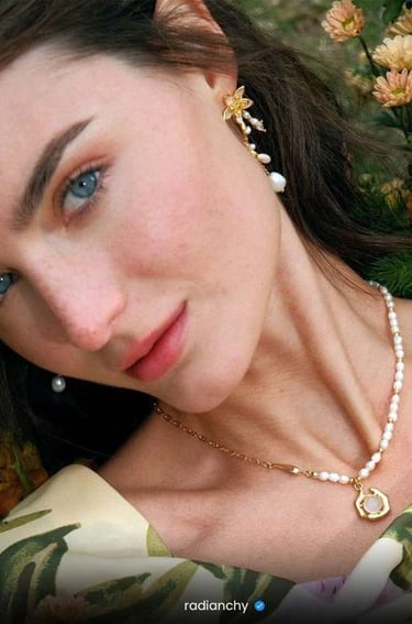a woman with a pearl necklace and pearl earrings