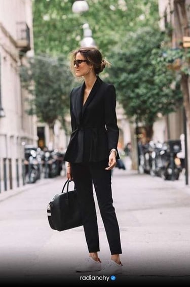 a woman in a black suit and sunglasses