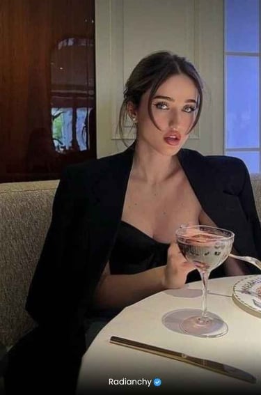 a woman in a black dress sitting at a table