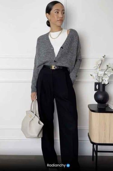a woman in a gray sweater and black pants