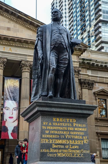 The statue of Sir Edmond Barry in front of the State Library Victoria in Melbourne