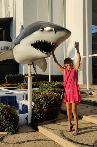 Sara the Author reaching up to spin the shark at Ixtapa Palace Resort Hotel