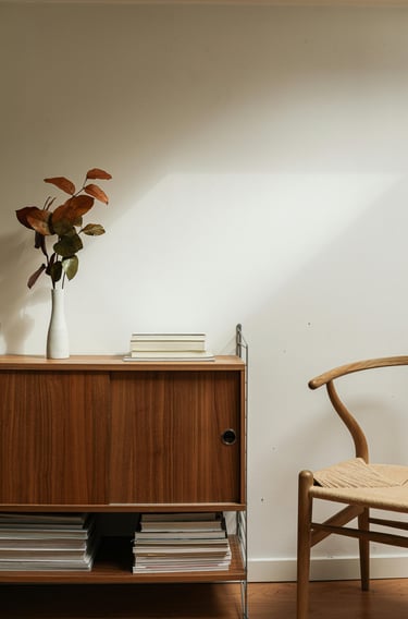 Interieur vintage minimaliste Enfilade avec des livres et une plante, à côté un fauteuil scandinave
