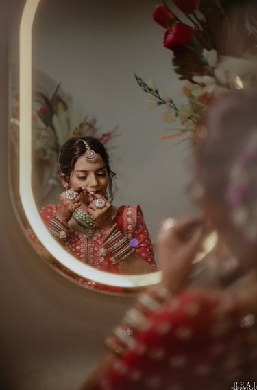 Gujarati bride getting ready in red bridal lehenga with HD bridal makeup and jewellery in Vadodara