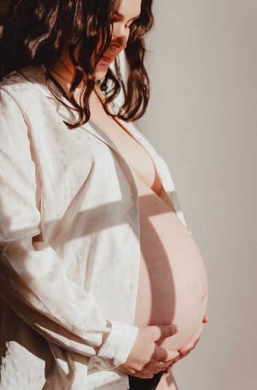 Photo de femme enceinte avec chemise blanche lumière douce en intérieur