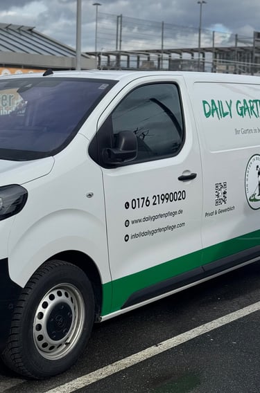 White Daily Gartenpflege commercial van parked in a lot, featuring professional gardening service branding and contact