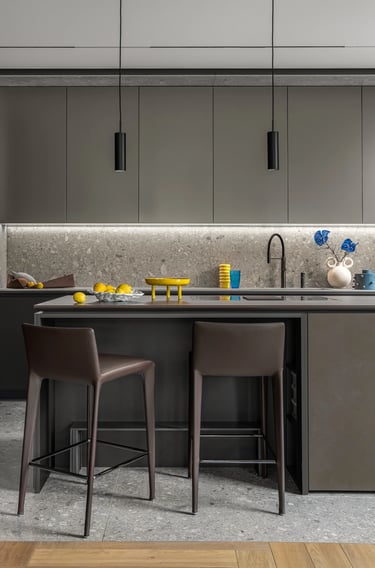 Grafitowa zabudowa kuchenna z oświetleniem LED, nowoczesne hokery i ściana z lastryko.