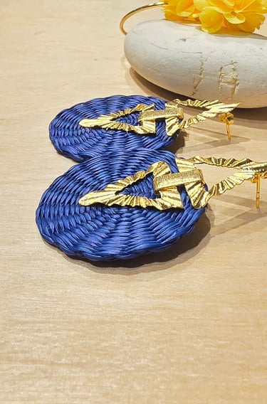 a pair of earrings with gold leaf earrings
