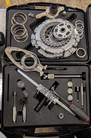 Professional dual-clutch transmission tool kit with clutch assembly and specialized repair hardware.