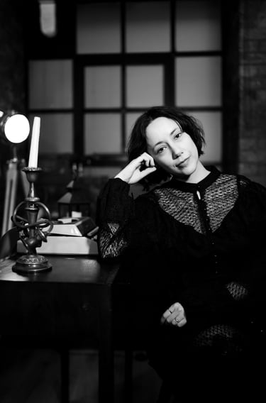 B&W picture of Maria sitting down next to a desk