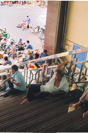 Vietnamese vendor relaxing on the stairs in Saigon China town market