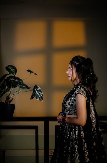 Side profile Indian bride wearing elegant black lehenga with professional bridal makeup and soft cur