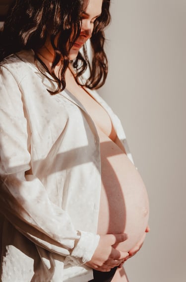 Photo de femme enceinte avec chemise blanche lumière douce en intérieur